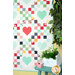 A shot of the right side of the quilt, showing the patchwork and binding details, next to coordinating summer decor and greenery.