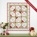 The completed Forever Sisters Charm Quilt colored in rich red, pink, and green fabrics from the A Very Sweet Christmas collection, hung on a white paneled wall above a green armoire, staged with coordinating décor.