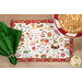 A top-down shot of the placemat staged with a coordinating cloth napkin and baked goods.