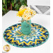 A shot of the table topper staged on a white table with coordinating florals in a painted mason jar.