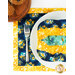 A top-down shot of a bowl cozy staged on a white, ornate plate sitting on a coordinating Sunlit Serenade placemat.