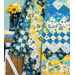 A close up shot of the quilt hung over a white ladder, demonstrating fabric and drape details.
