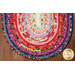 A top down shot of half of the Jelly Roll Rug, showing details on the vibrant purple, red, pink, and white fabrics.