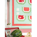 A closer look at the quilt, with a red tray of watermelon and matching jars peeking into frame from the left side.