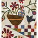 A close up on the appliqué pot of flowers with a small appliqué bird beside it, showcasing patchwork details on the background and star as well.