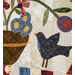 A close up on the appliqué piecing, a scene of a small bird beside a basket of colorful florals. Top stitching and top quilting details can be seen.