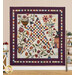 The completed Stellar Garden Quilt, colored in rich fabrics from the Flossie's Flowers collection by Henry Glass Fabrics. The quilt is hung on a warm beige paneled wall and staged with coordinating farmhouse decor.