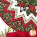 A stylized close up on the topper, showing details on the floral and leafy prints of the topper. Coordinating decor peeks into frame from the bottom.