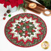 The completed Point of View Folded Star Table Topper colored in bold green, red, and white fabrics from the Berry & Pine collection by Moda Fabrics, staged on a white table with coordinating kitchen and holiday decor.