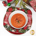 A top-down image of the bowl cozy holding a bowl of tomato soup, surrounded by coordinating holiday décor.