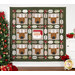 The Christmas Crew quilt featuring reindeer and Santa blocks, displayed near a Christmas tree and decorations.
