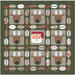 A festive quilt design featuring reindeer faces and a Santa figure framed by holiday-themed leaves.