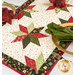 A close up shot of the runner staged on a white table and set with coordinating tableware and festive decor.