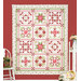 The completed A Very Sweet Patchwork BOM quilt, colored in white, green, pink, and red fabrics from the A Very Sweet Patchwork Christmas collection, staged on a red wall with coordinating furniture.