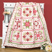 The completed quilt, artfully draped over a white armoire against a red wall with coordinating decor.