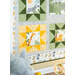 A shot of the bottom left corner of the quilt, demonstrating quilting star, fabric, piecing, border, and binding details. A stuffed toy elephant can be seen in the bottom left corner.