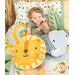 A young boy sits on a cabin bed holding a teddy bear, surrounded by the minky pillows as he lays on a coordinating Sunny Safari pillow and patchwork quilt.
