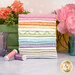 A stack of the fabrics included in the Kimberbell Basics Flannel Sweet Dreams FQ Bundle, with flowers and jars and thread.