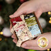 A model holds the little wooden box full of Emmitt & Ivy fabrics. A sparkling Christmas tree peeks through in the background.