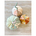 A top-down shot of the finished fabric pumpkins displayed on a wood table.