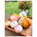 A shot of the finished fabric pumpkins displayed on a front porch in a small wooden box.