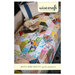 The front of the Nuts & Bolts Quilt Pattern, showing the finished quilt draped over a bed.