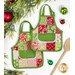 The two completed hot pads colored in bright green, red, and cream fabrics, from the Buon Natale collection, staged on a clean white background with coordinating holiday decor and a wooden spatula.