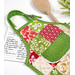 A top down shot of one of the completed hot pads, staged with coordinating decor, a recipe card, and a wooden spoon.