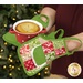 A model demonstrates the use of the Apron Hot Pads, holding a small ramekin with a pie inside it.