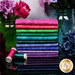 A stack of the brightly colored fabrics from the Equinox Electric Fat Quarter Bundle, staged with coordinating décor.