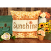 The finished August pillow wrap kit, a cream and orange wrap with orange sunshine borders and appliqué letters that read 