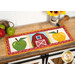 A shot of the project as a table runner, displayed horizontally on a wooden table set with coordinating late summer decor.