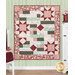 The completed Comfort of Psalms Quilt Kit, colored in red, green, cream, and pink fabrics from the Regal Rose collection, hung on a green-paneled wall and staged with coordinating furniture and décor.