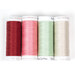 Four spools of thread in red, pink, mint, and ecru, isolated on a white background.
