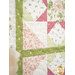 A close up on the quilt, showcasing a corner of the quilt block, demonstrating fabric, piecing, sashing, and border details.