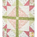 An up close shot of a patchwork quilt featuring a star-shaped design with pink, green, and white floral prints.