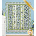 The completed Flower Girl quilt colored in green, cream, blue, and navy from the Nantucket Summer collection, hung on a blue-paneled wall with coordinating floral décor on either side of the quilt.