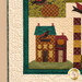 A close up on the lower left block of the quilt, displaying a plaid orange house with a blue and red roof.