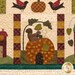 A close up on the bottom center block featuring appliqué pumpkin with a squirrel on top, demonstrating fabric print and color details.