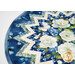 A close up on the topper, showing detail on the color and prints of the Blue Harmony fabrics, featuring soft white florals, small blue florals, and bright blue butterflies.