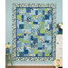 A head-on shot of the Easy as ABC and 123 Quilt colored in blue, green, and white fabrics from the Blue Harmony collection, hung on a blue wall and staged with coordinating flowers.