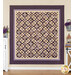 The completed Hummingbird Hill quilt, colored in rich cream and purple fabrics from the Plumberry III collection, hung on a cream wall and staged with coordinating flowers and furniture.