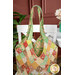 A shot of the Mondo bag on a white chair beside a white table; a coordinating jar of flowers peeks into frame from the right side.