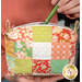 A close up on the mini bag as a model places a green Frixion pen into the bag, demonstrating fabric color and details.