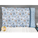The completed Magic Pillowcase, colored with light blue and dark blue flannel fabrics with snowmen from the Snow Much Fun Flannel collection, staged on a bed with a white knit blanket.