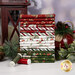 A stack of the fabrics included in the Holiday Spirit collection, with plants and a larntern and a bell.