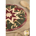 A shot of the hot pad staged next to a wooden spoon, demonstrating fabric, piecing, folded star center, and binding details.