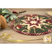 A shot of the round hot pad staged with a spool of sparkly gold ribbon and a sprig of mistletoe.