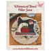 Front cover of the pattern showing the completed project on resting on plate of quilting notions.
