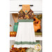 The completed Hanging Towel colored in brown, orange, and green fabrics from The Awe of Autumn collection, staged on a kitchen drawer with coordinating decor.